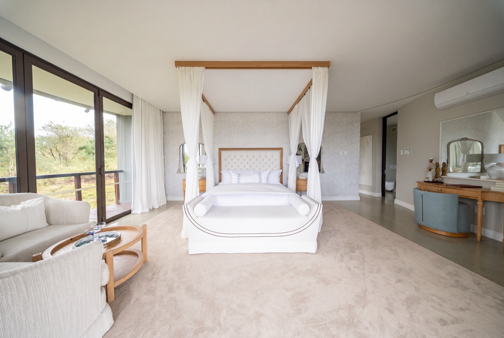 Four-poster suite against the bushveld window